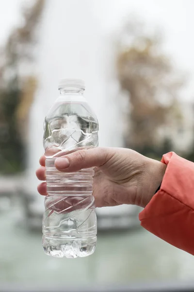 Hand hold bottle mineral water.