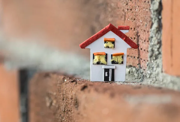 Casa em miniatura e parede de tijolo — Fotografia de Stock