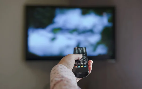 TV and hand hold remote control. — Stock Photo, Image