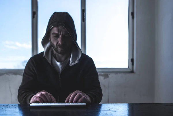 Hacker with laptop. Window in background