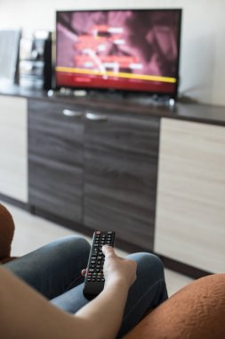 Kadın Tv uzaktan kumanda tutun. TV arka planda.