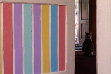 Oda kapıları açık. Ahşap kapılar renkli çizgilerle boyanmış.
