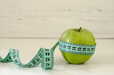 Yeşil elma santimetre Beyaz ahşap arka plan zekâ üzerinde sarılı