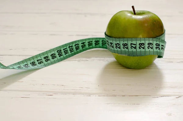 Yeşil elma santimetre Beyaz ahşap arka plan zekâ üzerinde sarılı — Stok fotoğraf