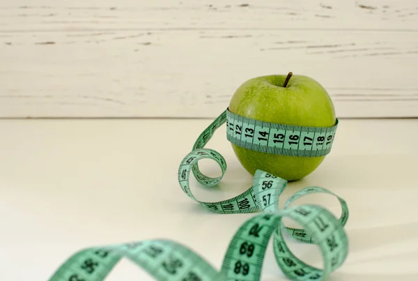 Yeşil elma santimetre Beyaz ahşap arka plan zekâ üzerinde sarılı — Stok fotoğraf