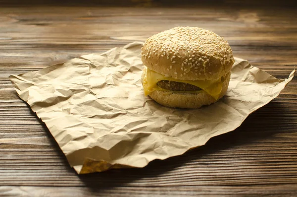 Чизбургер на бумаге на деревянном фоне с пространством f — стоковое фото