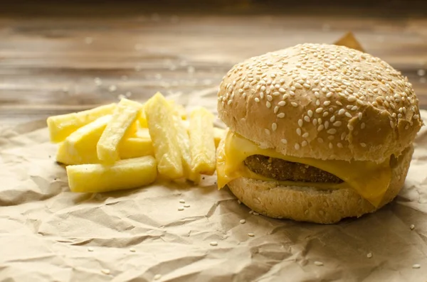Чизбургер с жареной картошкой и чили на ремесленной бумаге на — стоковое фото