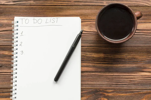 Blocco note con scritta frase "to do list" e tazza di caffè su w — Foto Stock