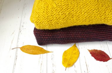 Beyaz tahta backg bir yığın kazak ve kuru sonbahar yaprakları