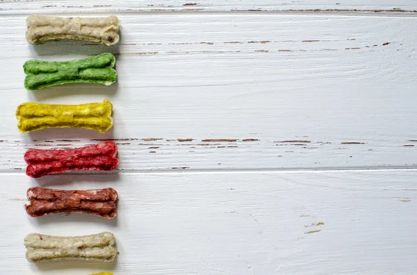 Delicious Chewing Colored Bones Dogs Different Tastes White Wooden Background — Stock Photo, Image