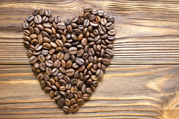 Heart from coffee beans on wooden background