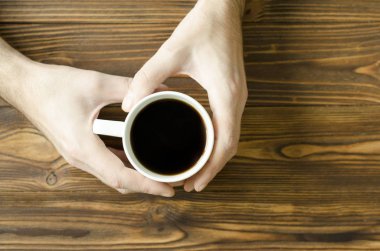 bir fincan kahve ahşap arka plan üzerinde tutan adamın elleri