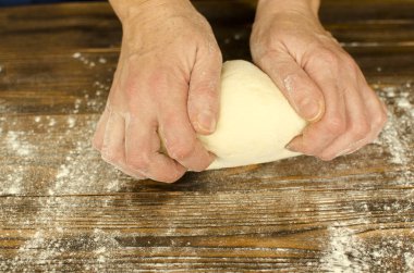 El ahşap arka plan üzerinde hamur yoğurmak