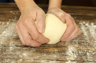 El ahşap arka plan üzerinde hamur yoğurmak