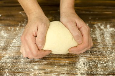 El ahşap arka plan üzerinde hamur yoğurmak