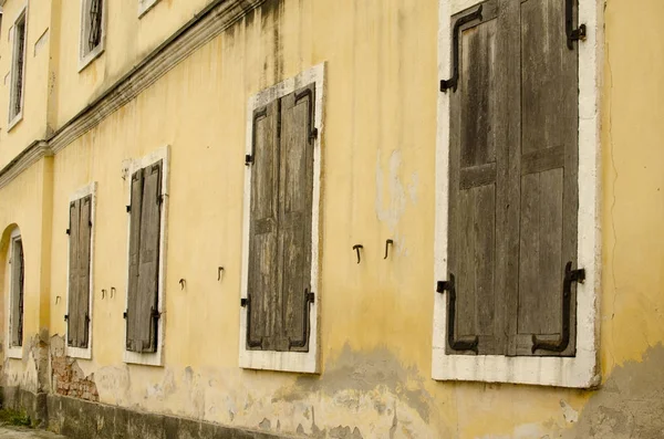 Mur de vieux bâtiment avec fenêtre avec volets fermés en bois — Photo