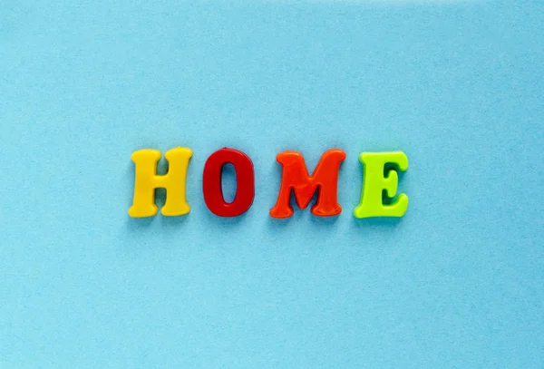 Mot "maison" de lettres magnétiques en plastique sur fond bleu — Photo