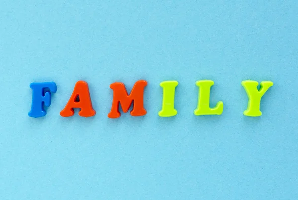 Слово "семья" пластиковых магнитных букв на синем фоне — стоковое фото