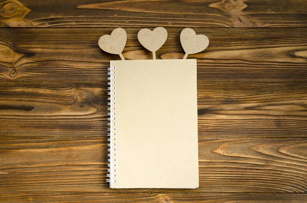 Kraft papier notepad met het hart op de houten tafel. kopie ruimte — Stockfoto