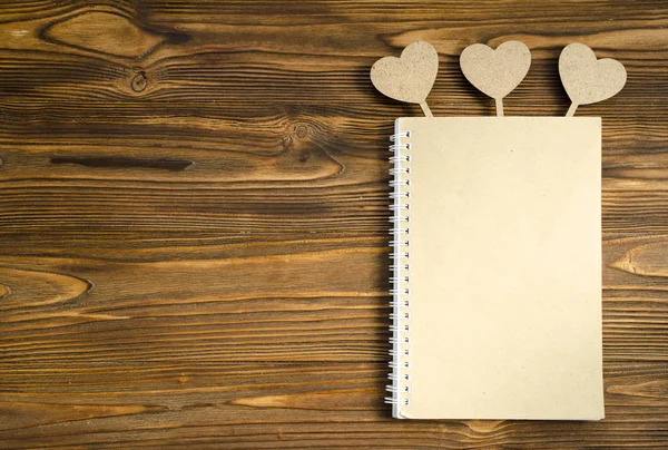 Kraft papier notepad met het hart op de houten tafel. kopie ruimte — Stockfoto