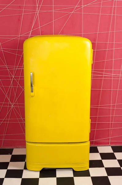 Vieux réfrigérateur rétro vintage jaune sur fond rose Image En Vente