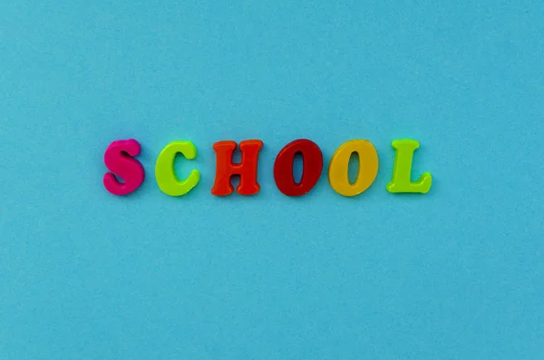 Kleurrijke woord ' school ' van magnetische letters op blauw papier backg — Stockfoto