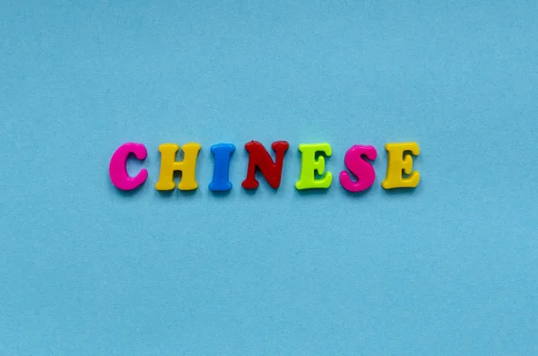 Mot "chinois" de lettres magnétiques en plastique coloré sur papier bleu — Photo