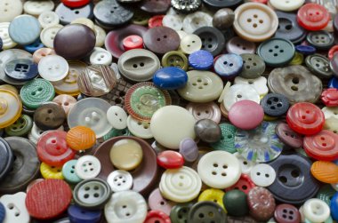 Colored plastic buttons on brown wooden background