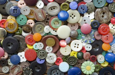 Colored plastic buttons on brown wooden background