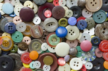 Colored plastic buttons on brown wooden background