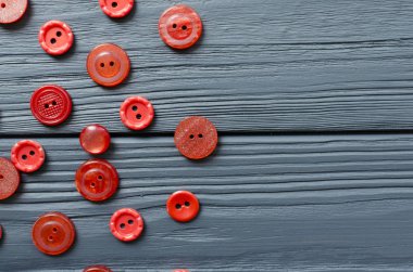 Red plastic buttons on grey wooden background