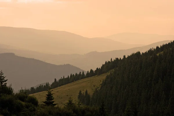 Landschap met oranje silhouetten van externe bergketens in t — Stockfoto