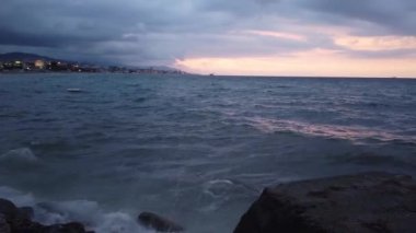 İtalya 'da, gün batımında Savona kıyısı yakınlarında Tyrhenian Denizi' nin fırtınalı dalgaları