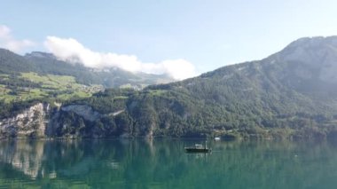 Walensee 'de küçük bir tekne ve göl çevresindeki dağlar, İsviçre' nin güzel doğası.