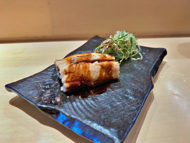 Omakase restoranında ızgara balık suşisi.