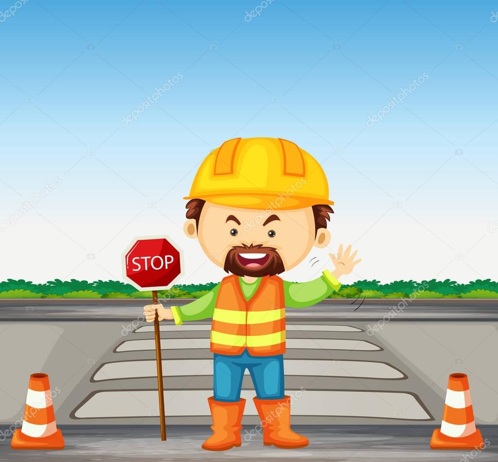 Road worker holding stop sign on the road