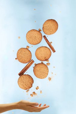 El, tarçın çubuklarıyla uçan kurabiyeler tutuyor.