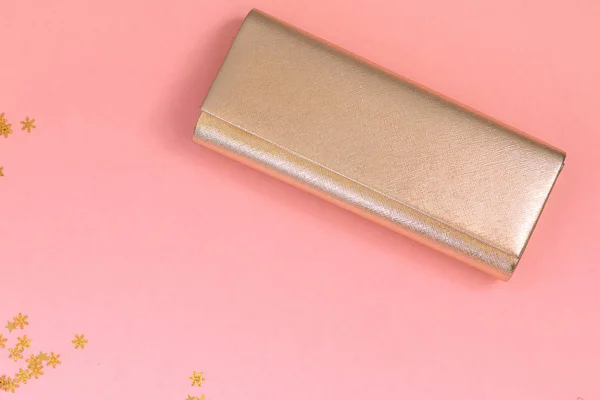 Golden clutch bag isolated on pink background with golden stars, space for text, New year card template design