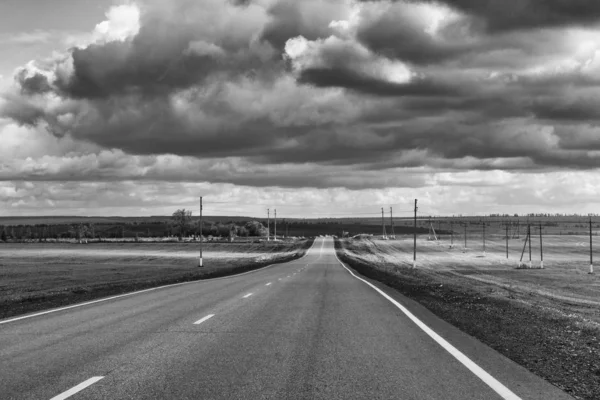 Black and white road landscape with dramatic clouds