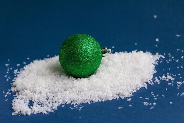 Groene heldere glanzende kerstbal geïsoleerd op sneeuw, sjabloon met ruimte voor tekst — Stockfoto