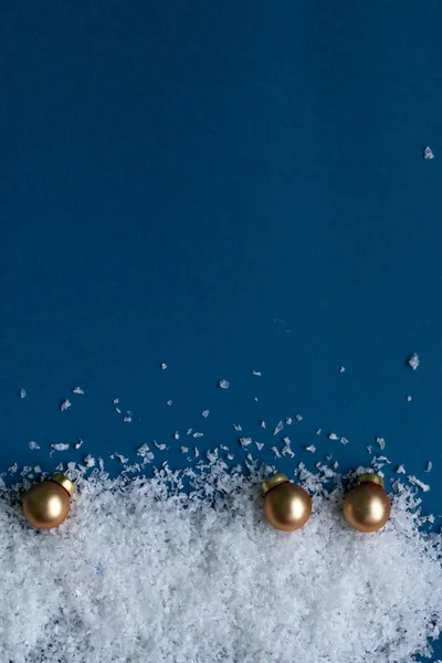 Decoración navideña dorada aislada sobre fondo azul, plantilla para tarjeta de felicitación con espacio para texto — Foto de Stock