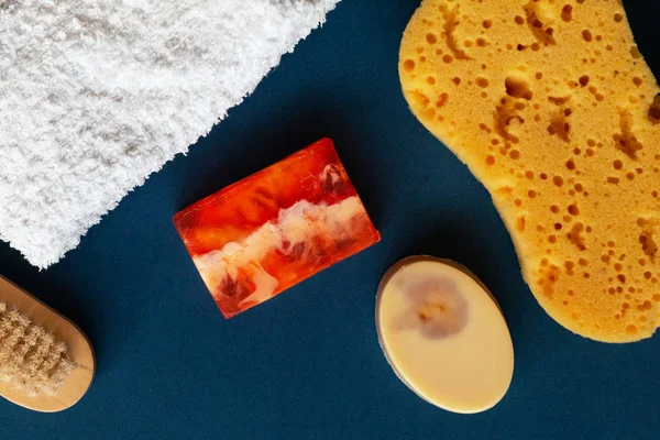 Accesorios de baño, jabón artesanal y toalla blanca sobre fondo azul. Aromaterapia concepto orgánico —  Fotos de Stock