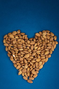 Badem tohumları dokusu mavi arkaplan üzerinde üst görünüm, metin için boş alan, organik sağlıklı gıda konsepti, tahıl sesi