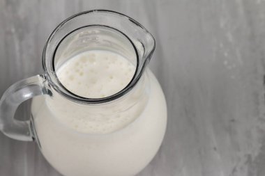 Cam sürahide Kefir gri arka planda izole, sağlıklı yemek ve diyet konsepti, metin için boş alan