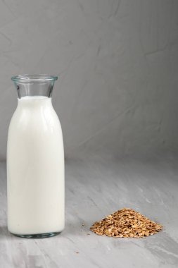 Beyaz cam şişedeki süt gri arkaplan, üst görünüm ve metin için boş alan