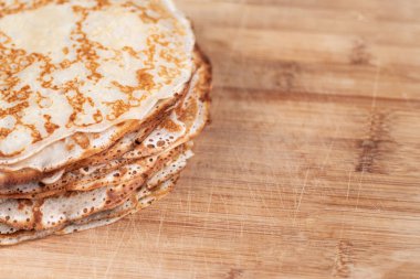 Metin için boş alanı olan ve seçici bir odak noktası olan bir tabakta bir yığın geleneksel leziz krep. Ev yapımı aile kahvaltısı.