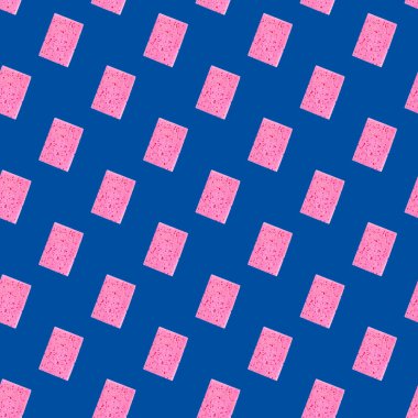 Bulaşıkları mavi arka planda yıkamak için pürüzsüz pembe sünger deseni