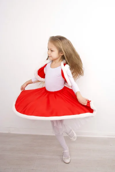 Маленькая девочка в рождественском платье танцует — стоковое фото