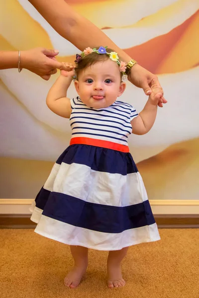 Niña aprendiendo a caminar y mostrando la lengua . — Foto de Stock