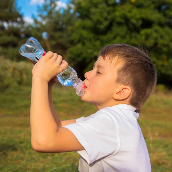 Niño bebe agua de una botella —  Fotos de Stock